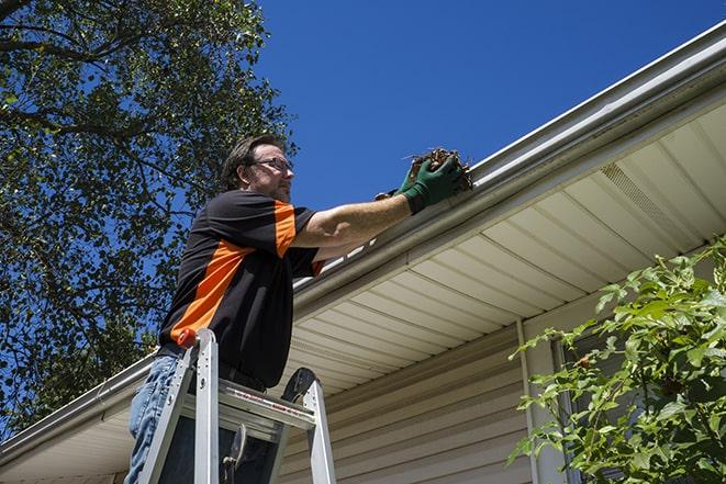 neighborhood handyman repairing rain gutters in Bay Shore, NY